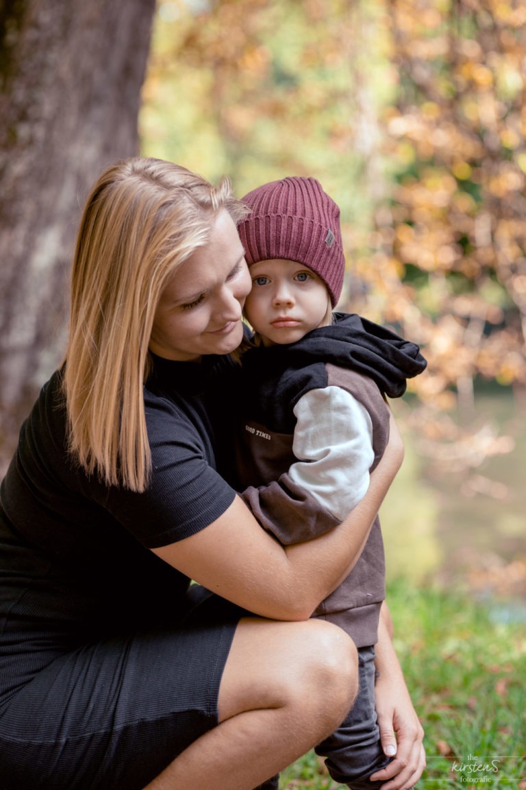 Familienfotos :Frau mit Sohn im Arm mit roter Mütze im Herbst